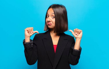 İspanyol kadın gururlu, kibirli ve kendinden emin, tatmin olmuş ve başarılı görünüyor, kendini işaret ediyor.