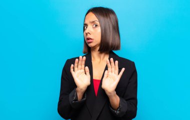 İspanyol kadın korkmuş, geri çekiliyor ve korku ve panik içinde bağırıyor, kabusa tepki veriyor.