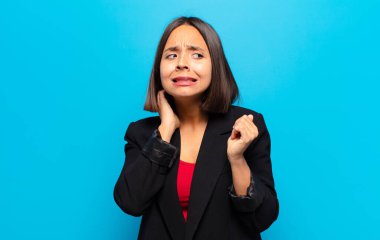 İspanyol kadın kendini stresli, hayal kırıklığına uğramış ve yorgun hissediyor. Endişeli ve sorunlu bir bakışla boynunu okşuyor.