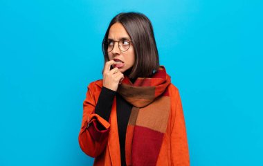 Şaşırmış, gergin, endişeli ya da korkmuş bakışları olan İspanyol bir kadın kopya boşluğuna doğru bakıyor.