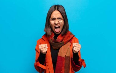 İspanyol kadın sinirli, sinirli, sinirli bakışlar ve sıkı yumruklar ile agresif bir şekilde bağırıyor.