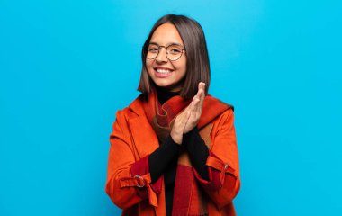 İspanyol kadın kendini mutlu ve başarılı hissediyor, gülümsüyor ve alkışlıyor, alkışlarla tebrik ediyor.