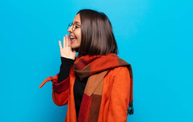 İspanyol kadın profil görüşü, mutlu ve heyecanlı görünüyor, bağırıyor ve kenardaki boşluğu kopyalamak için arıyor