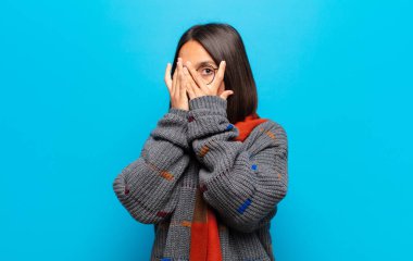 İspanyol kadın korkmuş ya da utanmış hissediyor. Gözleri yarı kapalı ya da elleri kapalı dikizliyor ya da dikizliyor.