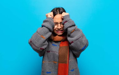 İspanyol kadın stresli ve endişeli, depresif ve hayal kırıklığına uğramış hissediyor, iki elini de başa kaldırıyor.