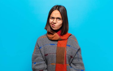 Hispanik kadın kendini şaşkın ve şüpheli hissediyor, merak ediyor ya da karar vermeye çalışıyor.