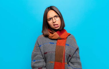 hispanic woman feeling puzzled and confused, with a dumb, stunned expression looking at something unexpected