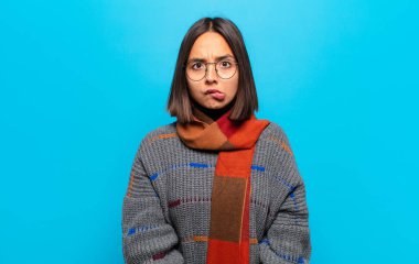 Hispanik kadın, hangi seçeneği seçeceğine karar veremediğini ve sorunu çözmeye çalıştığını düşünüyor.