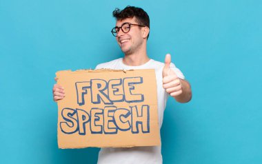 Genç adam gururlu, kaygısız, kendinden emin ve mutlu, olumlu gülümsüyor.