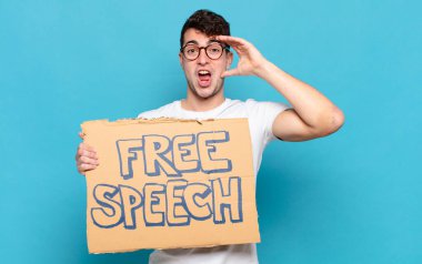 Genç adam mutlu, şaşkın ve şaşırmış görünüyor, gülümsüyor ve inanılmaz ve inanılmaz iyi haberleri fark ediyor.