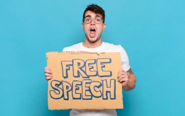 Genç adam şok olmuş ya da şaşırmış görünüyor, ağzı açık bir şekilde 