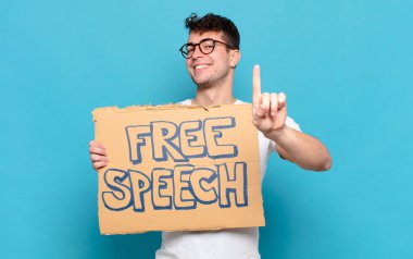 Genç adam gururla gülümsüyor ve gururla bir numaralı pozunu veriyor, kendini lider gibi hissediyor.