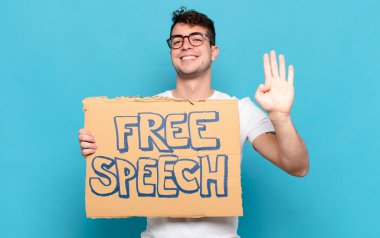 Genç adam gülümsüyor ve arkadaş canlısı görünüyor, dört ya da dört numarayı gösteriyor, eli önde, geriye doğru sayıyor.