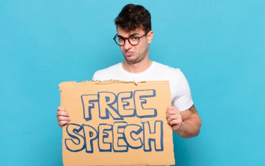 Genç adam üzgün, üzgün ya da kızgın ve olumsuz bir tavırla, anlaşmazlık içinde somurtuyor.