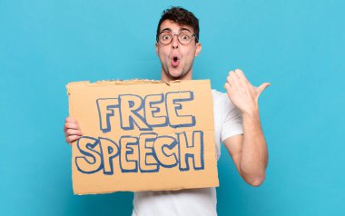 Genç adam inançsızlıktan şaşkın şaşkın bakıyor, yan taraftaki objeyi işaret ediyor ve diyor ki: