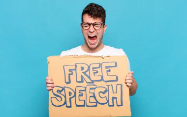 Genç adam agresif bir şekilde bağırıyor, çok kızgın, hayal kırıklığına uğramış, öfkeli ya da sinirli görünüyor.