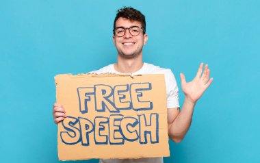 Genç adam mutlu, şaşırmış ve neşeli hissediyor, pozitif bir tavırla gülümsüyor, bir çözüm ya da fikir buluyor.