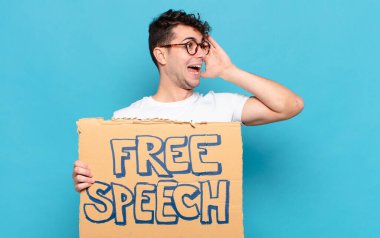 Genç adam mutlu, heyecanlı ve şaşırmış hissediyor, iki eli yüzü yana bakıyor.