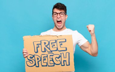 Genç adam öfkeli bir ifadeyle ya da yumruklarıyla başarıyı kutlarken agresif bir şekilde bağırıyor.