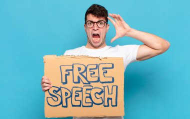 Genç adam elleri havada bağırıyor, öfkeli, sinirli, stresli ve üzgün hissediyor.