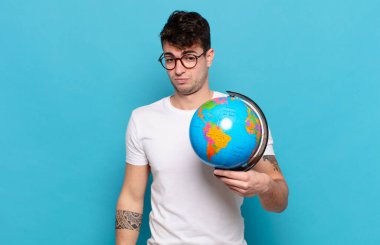 Genç adam üzgün, üzgün ya da kızgın ve olumsuz bir tavırla, anlaşmazlık içinde somurtuyor.