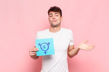 Genç adam şaşkın ve şaşkın hissediyor, şüpheci, farklı seçenekleri tartıyor veya komik bir ifadeyle seçiyor.