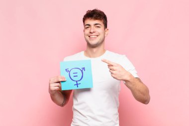 Genç adam heyecanlı ve şaşırmış görünüyor. Yana ve yukarıya doğru uzayı gösteriyor.