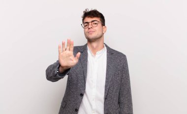 Genç adam ciddi, sert, hoşnutsuz ve kızgın görünüyor. Avuç içinin açık olması jesti durduruyor.