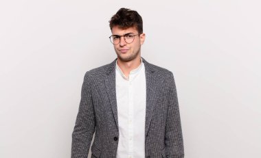 Genç adam üzgün, üzgün ya da kızgın ve olumsuz bir tavırla, anlaşmazlık içinde somurtuyor.