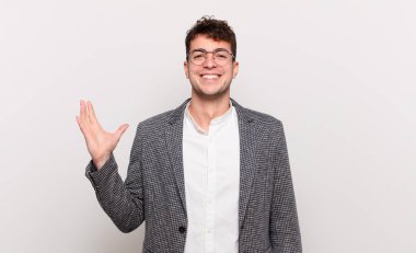 Genç adam mutlu, şaşırmış ve neşeli hissediyor, pozitif bir tavırla gülümsüyor, bir çözüm ya da fikir buluyor.