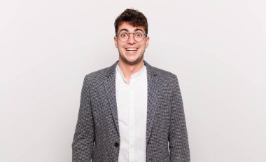 Genç adam mutlu ve hoş bir şekilde şaşırmış görünüyor. Büyülenmiş ve şok olmuş bir ifadeyle heyecanlanıyor.