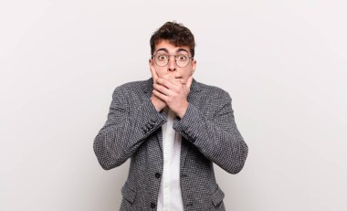 Delikanlı elleri ile ağzını kapatıyor, şok olmuş, şaşırmış bir ifadeyle, sır saklıyor ya da 