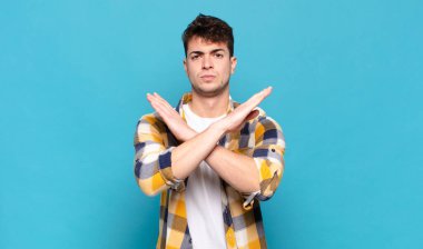 Genç adam senin bu tavırlarından rahatsız ve bıkkın görünüyor, yeter artık! Eller önde çapraz, durmanı söylüyor.