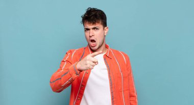 Öfkeli agresif bir ifadeyle kameraya bakan genç bir adam öfkeli, çılgın bir patron gibi görünüyor.