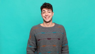 Genç adam mutlu ve hoş bir şekilde şaşırmış görünüyor. Büyülenmiş ve şok olmuş bir ifadeyle heyecanlanıyor.