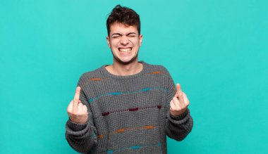 Genç adam kışkırtıcı, agresif ve müstehcen hissediyor. İsyankar bir tavırla orta parmağını hareket ettiriyor.