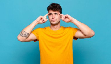 Genç adam kafası karışık ya da şüpheci, bir fikre odaklanmış, çok düşünüyor, kenarda boşluğu kopyalamak istiyor.