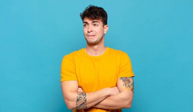 Genç adam şüphe ediyor ya da düşünüyor, dudağını ısırıyor ve kendini güvensiz ve gergin hissediyor.