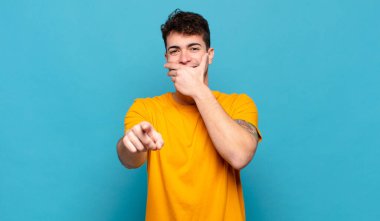 Genç adam sana gülüyor, kamerayı işaret ediyor ve seninle dalga geçiyor ya da alay ediyor.