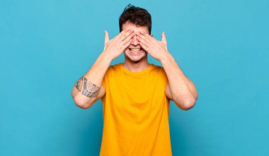 Genç adam gülümsüyor ve mutlu hissediyor, iki eliyle gözlerini kapatıyor ve inanılmaz bir sürpriz bekliyor.