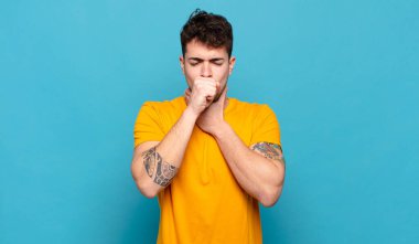 Genç adam boğaz ağrısı ve grip semptomlarıyla öksürüp duruyor.