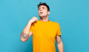 Genç adam stresli, endişeli, yorgun ve hayal kırıklığına uğramış, gömleğini çekmiş, sorunlu görünüyor.