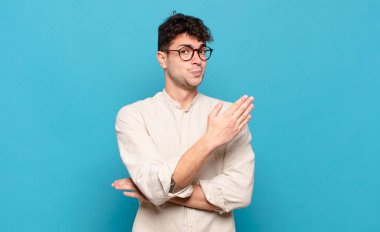 Genç adam kafası karışık ve bilgisiz, şüpheli bir açıklama ya da düşünceyi merak ediyor.