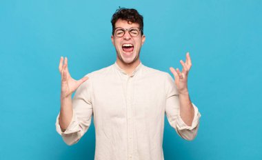 Genç adam öfkeyle bağırıyor, stresli hissediyor ve ellerini havaya kaldırıp neden ben diye bağırıyor.