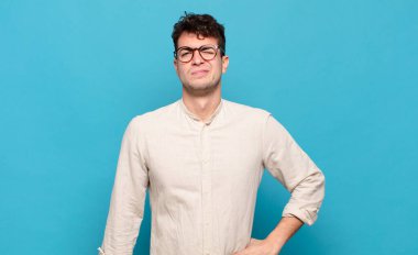 Genç adam mutlu ve arkadaş canlısı görünüyor, gülümsüyor ve sana olumlu bir tavırla göz kırpıyor.