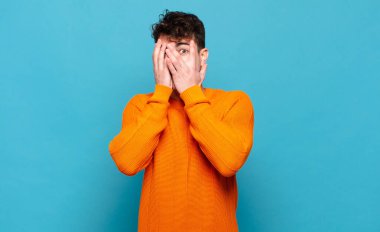 Delikanlı korkmuş ya da utanmış hissediyor. Gözleri yarı kapalı ya da ellerle dikizliyor ya da dikizliyor.