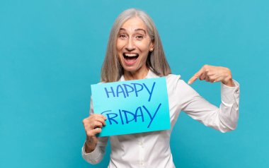 'Mutlu Cuma' tabelası olan orta yaşlı kadın.