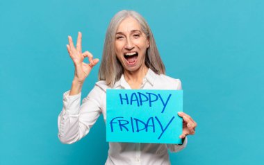 'Mutlu Cuma' tabelası olan orta yaşlı kadın.