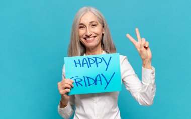 'Mutlu Cuma' tabelası olan orta yaşlı kadın.