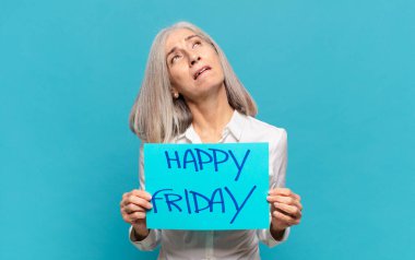 'Mutlu Cuma' tabelası olan orta yaşlı kadın.